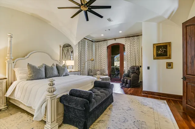 a bedroom with a large bed and a chandelier