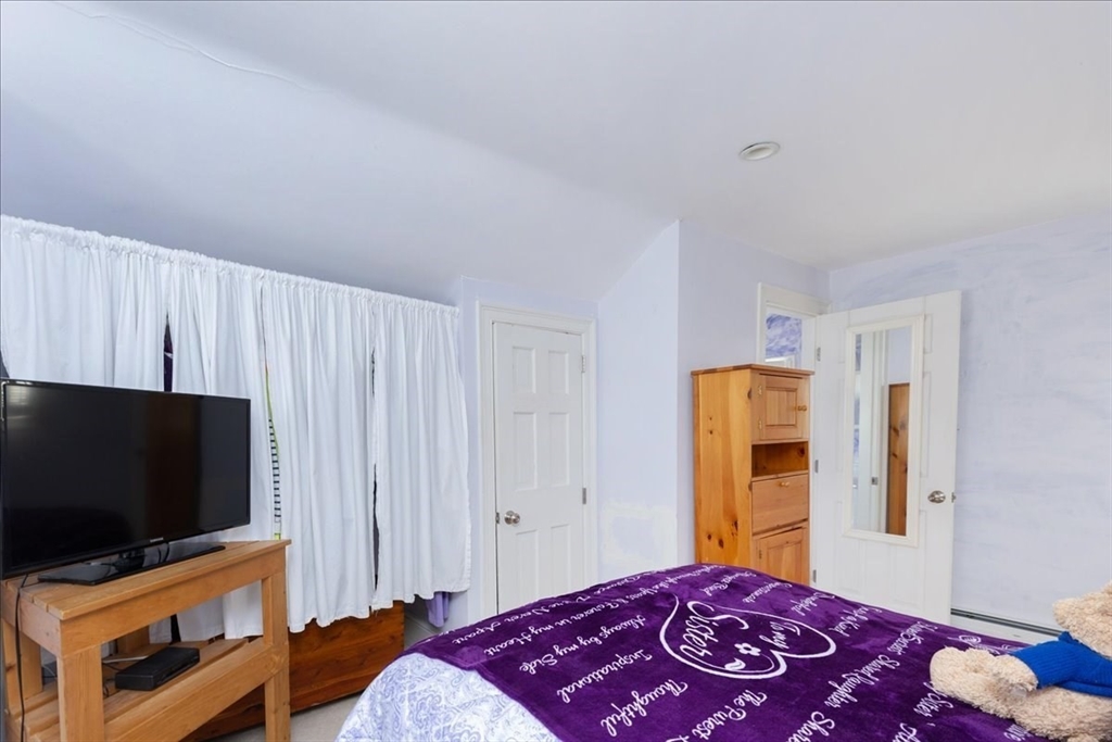 145 Evans Rd Extension Marblehead, MA 01945 - Photo 27 of 42 a bedroom with a bed and a flat screen tv