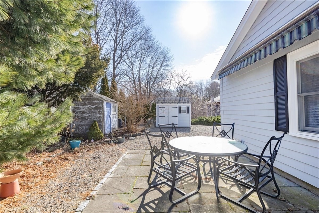 145 Evans Rd Extension Marblehead, MA 01945 - Photo 32 of 42 a view of a patio with a table and chairs and a barbeque with potted plants
