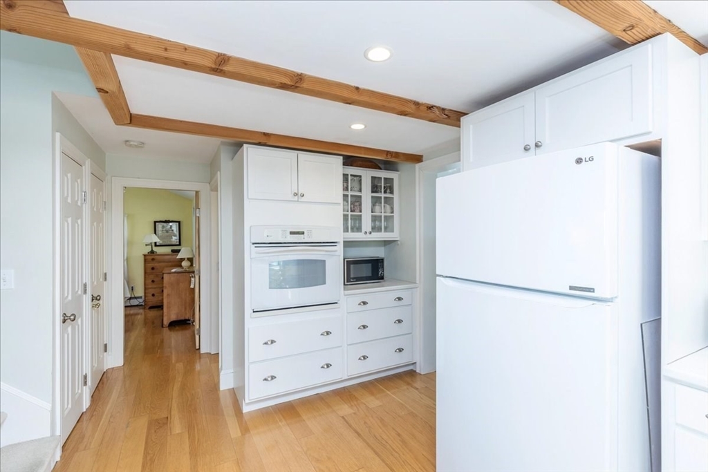 145 Evans Rd Extension Marblehead, MA 01945 - Photo 4 of 42 a kitchen with a refrigerator a stove and white cabinets
