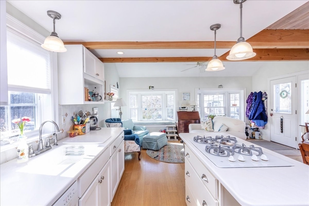 145 Evans Rd Extension Marblehead, MA 01945 - Photo 5 of 42 a kitchen with a refrigerator a stove a sink dishwasher and white countertops with wooden floor
