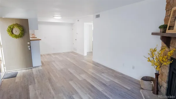 a view of a hallway with wooden floor and a potted plant