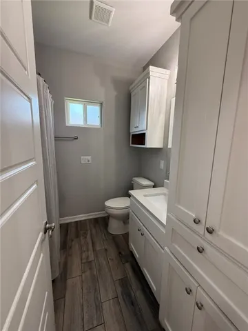 a bathroom with a toilet a sink and mirror