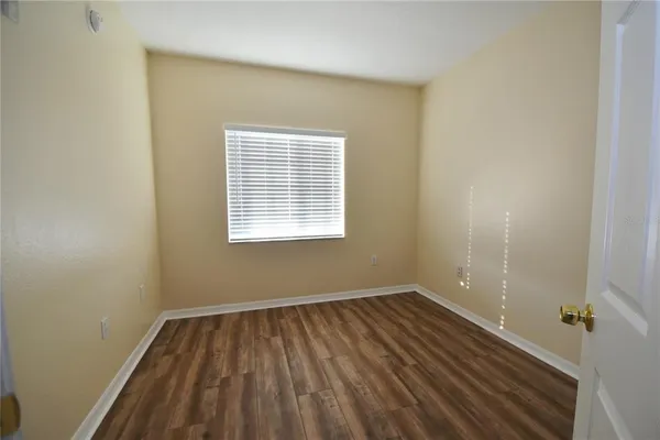 a view of a room with wooden floor and a window