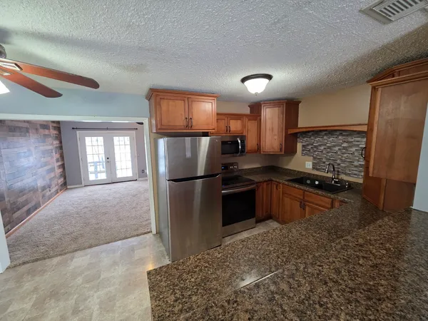 a kitchen with stainless steel appliances granite countertop a refrigerator stove and sink