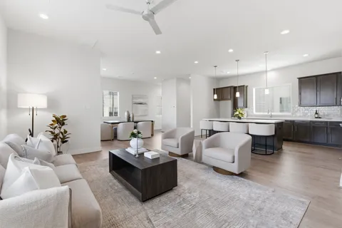 a living room with furniture kitchen view and a chandelier