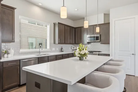a kitchen with cabinets appliances a sink and a counter top space