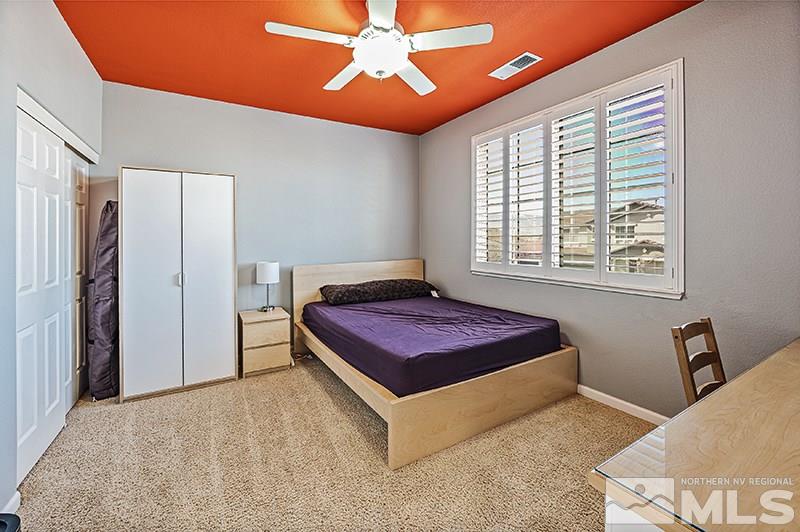 10460 Blockade Drive Reno, NV 89521 - Photo 21 of 25 a spacious bedroom with a bed and a chandelier