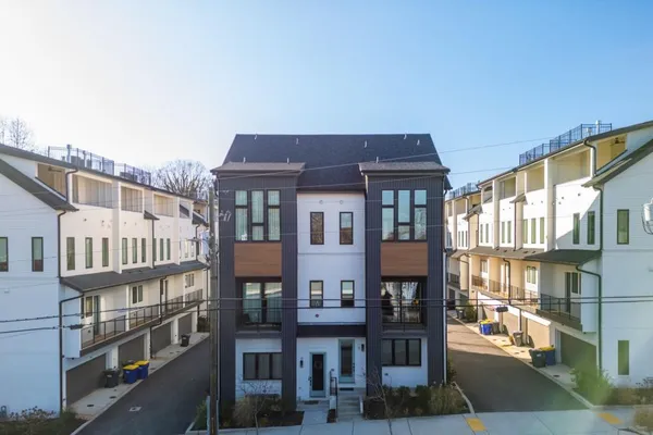 a front view of a residential apartment building with a yard
