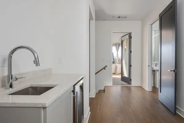 a kitchen with a sink and a refrigerator with wooden floor