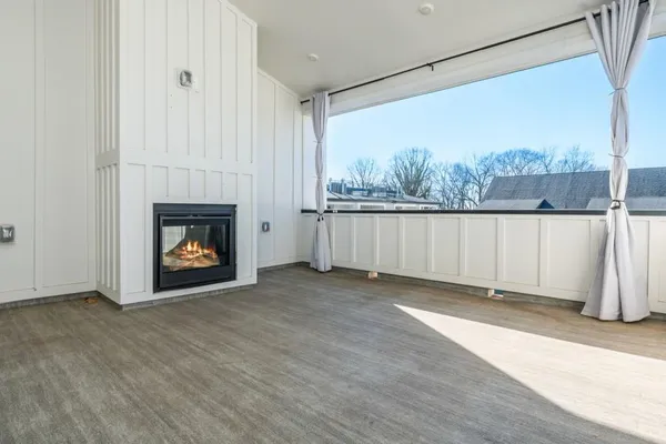 a view of an empty room with a fireplace and a window