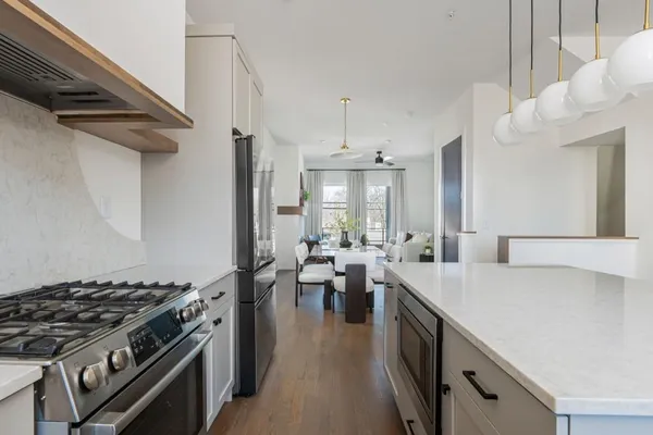 a kitchen with a stove and wooden floor