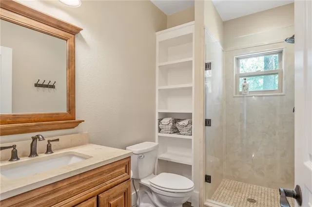 a bathroom with a granite countertop sink toilet a mirror and shower