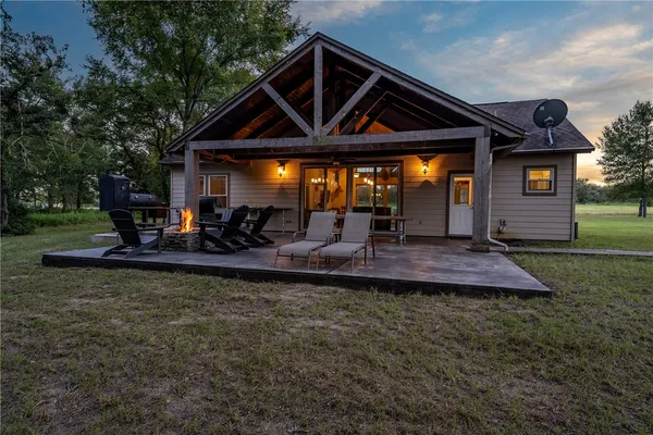 a view of a house with backyard and sitting area