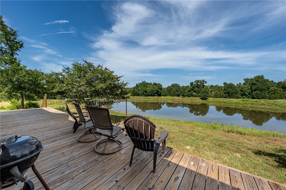 2033 Lcr 704, Unit COUNTYROAD Kosse, TX 76653 - Photo 21 of 31 a view of a lake with table and chairs next to yard