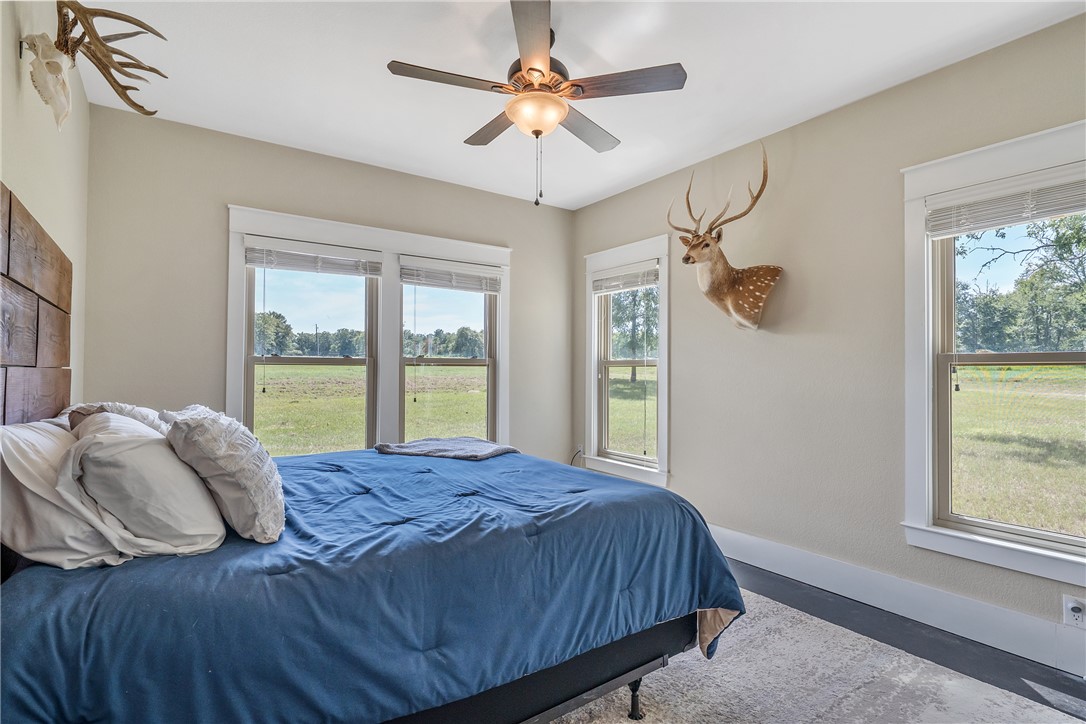 2033 Lcr 704, Unit COUNTYROAD Kosse, TX 76653 - Photo 9 of 31 a bedroom with a large bed and a chandelier