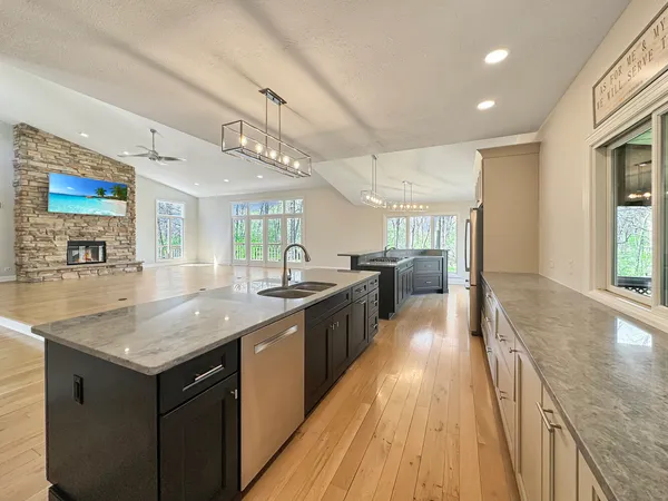 a view of an empty room with wooden floor fireplace and a window