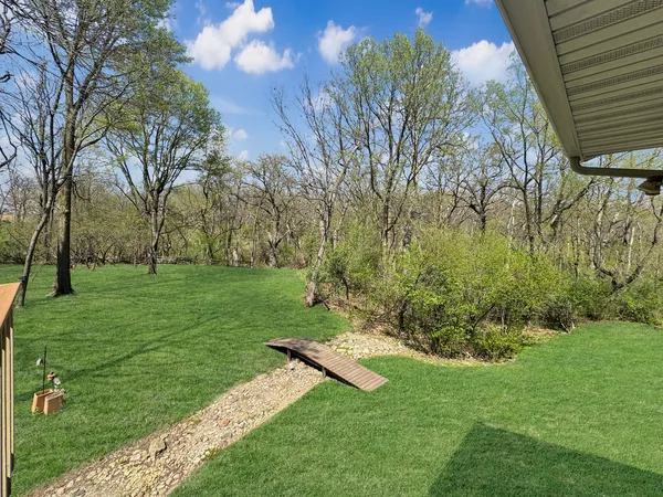 a view of a house with a big yard and large trees