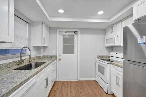 a kitchen with a refrigerator stove and white cabinets