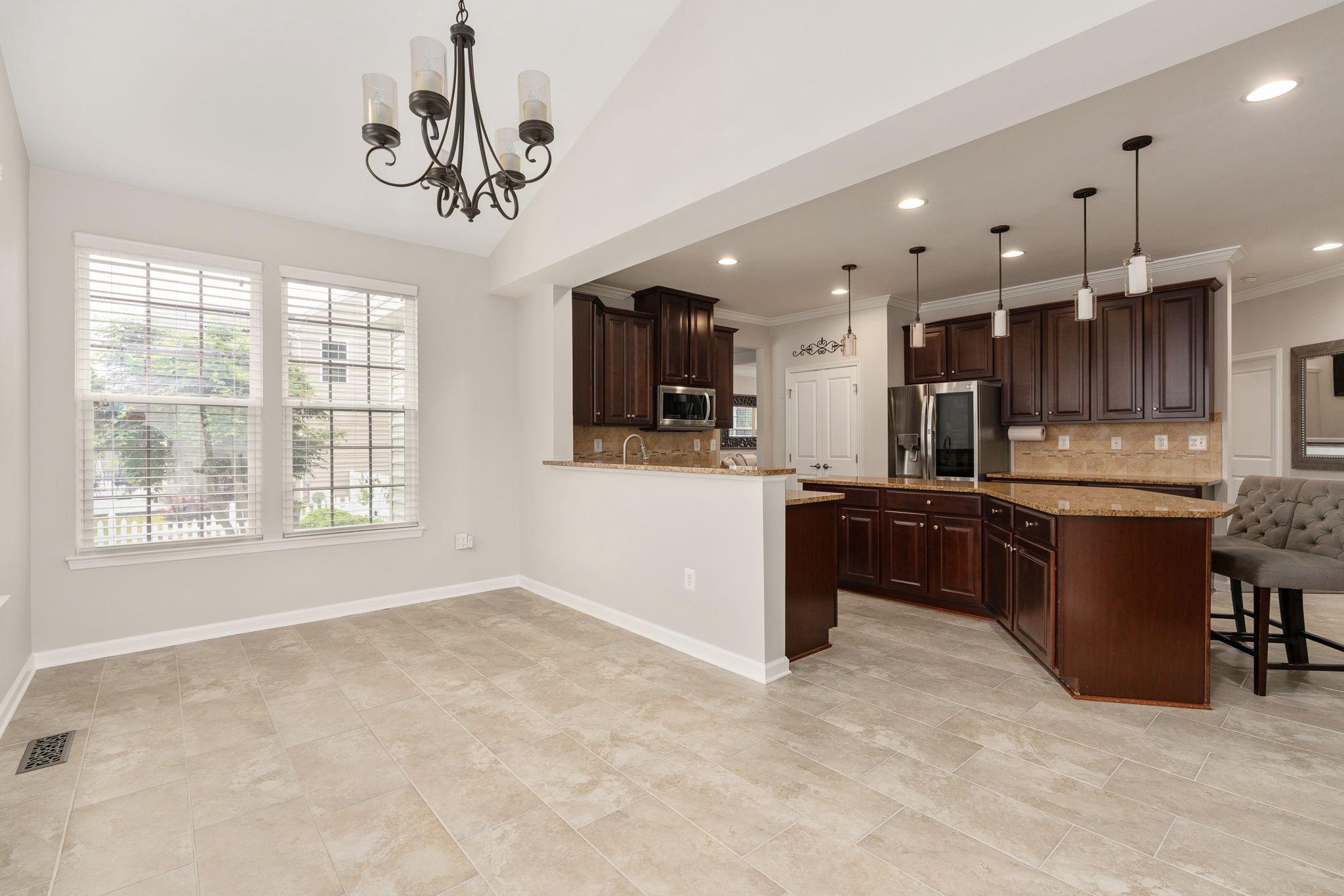 9417 Reservoir Road Fredericksburg, VA 22407 - Photo 21 of 76 a kitchen with stainless steel appliances kitchen island granite countertop a refrigerator oven a sink dishwasher with a dining table and chairs