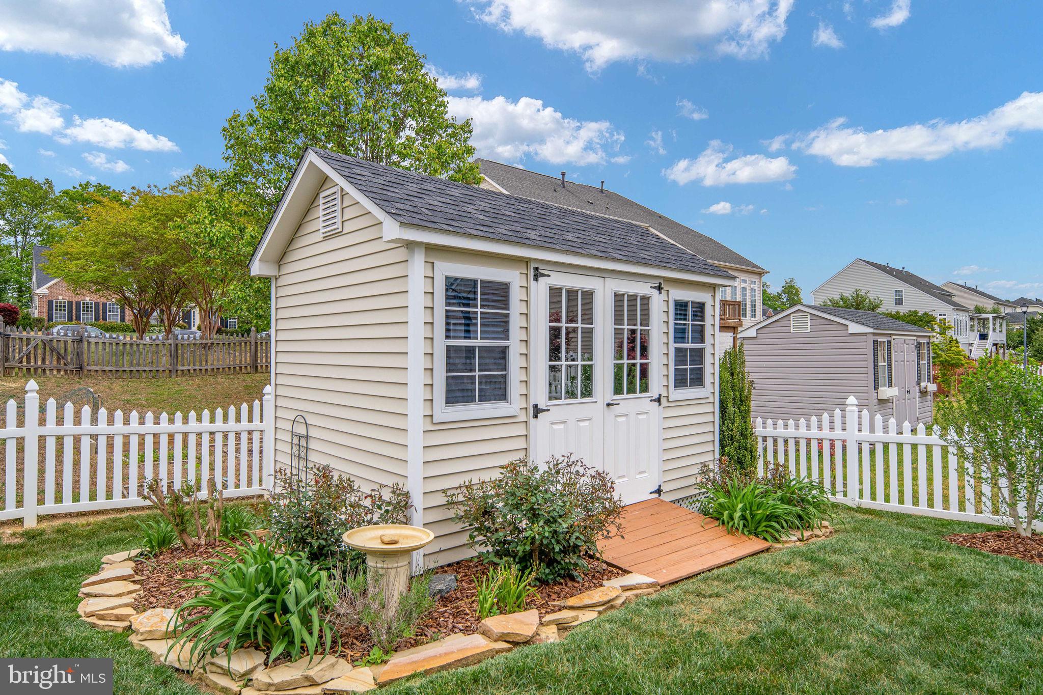 9417 Reservoir Road Fredericksburg, VA 22407 - Photo 73 of 80 Charming garden shed with lush greenery.