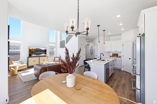 4646 Alder Drive, Unit 223 Mapleton, UT 84664 - Photo 5 of 35 Open-concept living area featuring high ceilings, wood-finish flooring, and abundant natural light from tall windows
