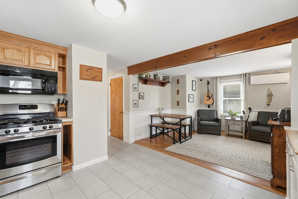 180 Wolcott Avenue West Springfield, MA 01089 - Photo 13 of 39 a living room with furniture a fireplace and a kitchen view