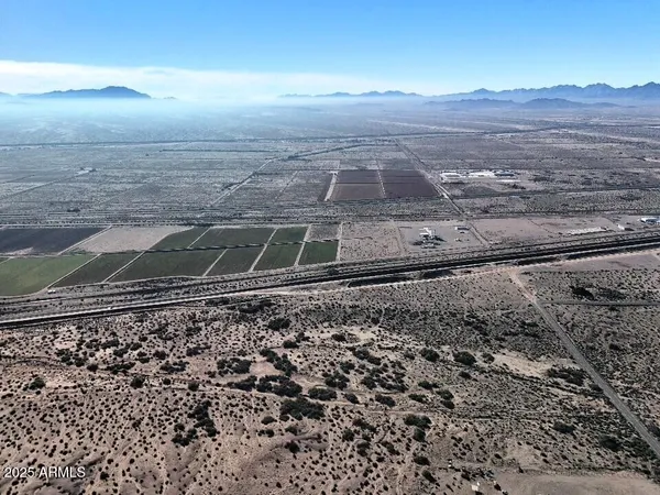 a view of a dry yard with wooden fence