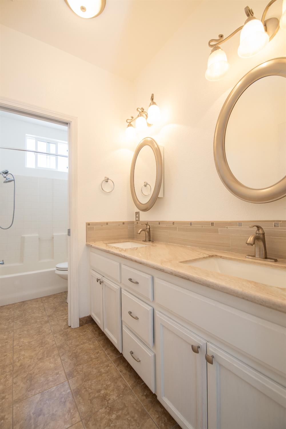 3601 Chant Drive Modesto, CA 95355 - Photo 16 of 23 a bathroom with a granite countertop sink and a mirror