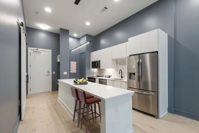 a kitchen with stainless steel appliances a refrigerator and a stove