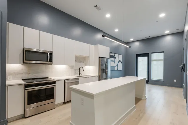 a kitchen with white cabinets and a refrigerator