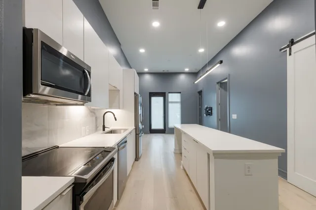 a view of a kitchen with a refrigerator and a sink