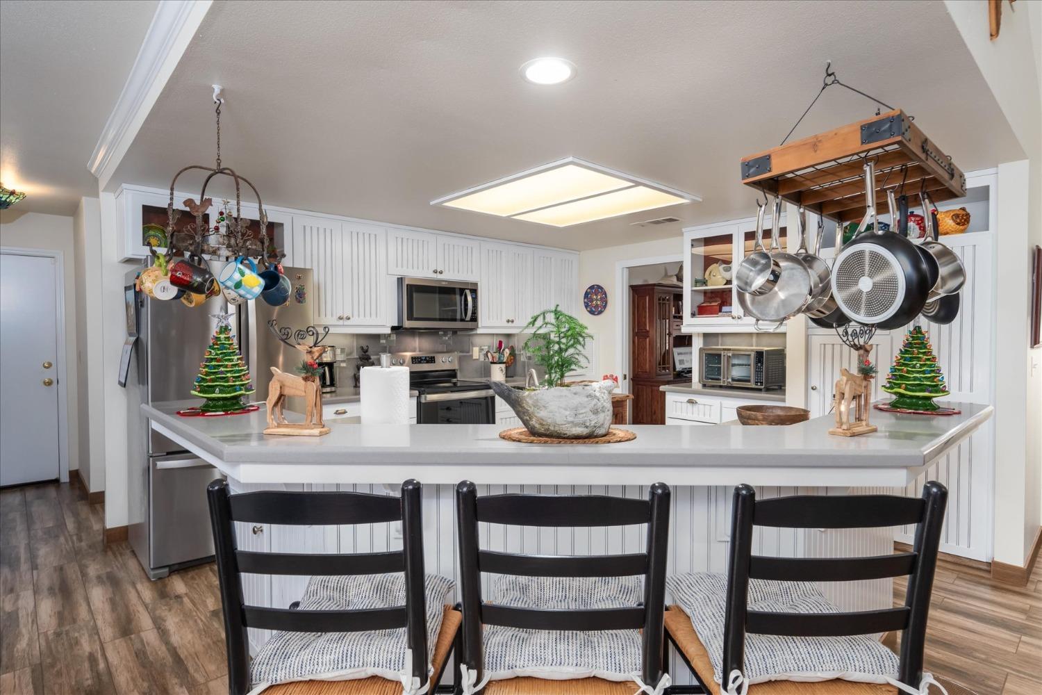 33655 River Knolls Road Coarsegold, CA 93614 - Photo 12 of 55 a view of a dining room and kitchen with furniture and a clock