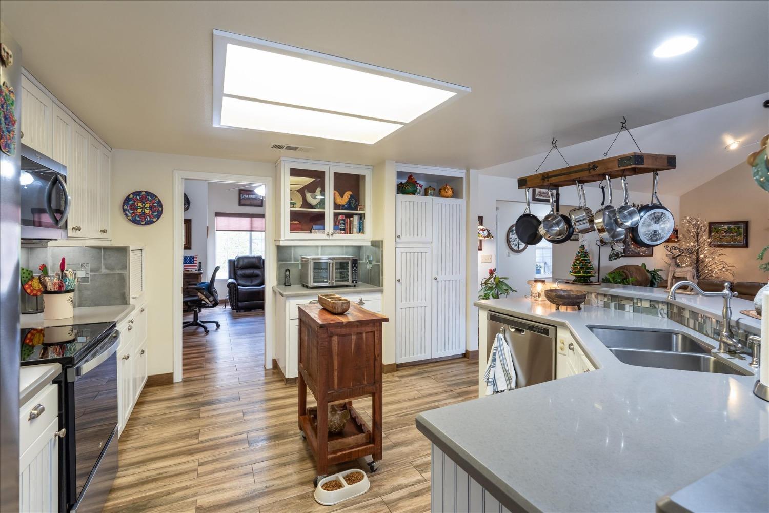 33655 River Knolls Road Coarsegold, CA 93614 - Photo 14 of 55 a kitchen with stainless steel appliances granite countertop a stove top oven a sink dishwasher and cabinets with wooden floor