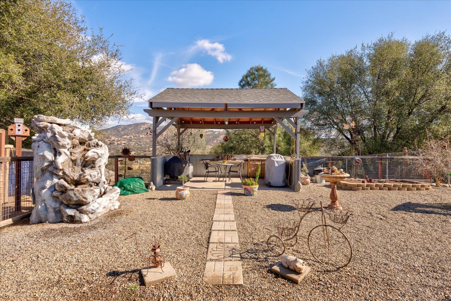 33655 River Knolls Road Coarsegold, CA 93614 - Photo 38 of 55 a view of a patio with a table and chairs under an umbrella
