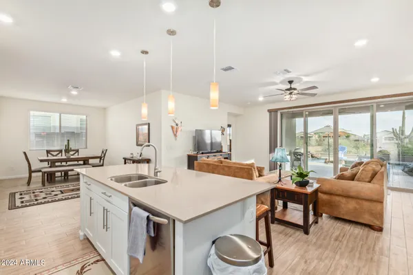 a open kitchen with stainless steel appliances granite countertop a sink a stove and a refrigerator with wooden floor