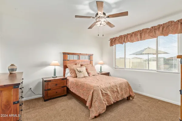 a bedroom with a bed chandelier and a window