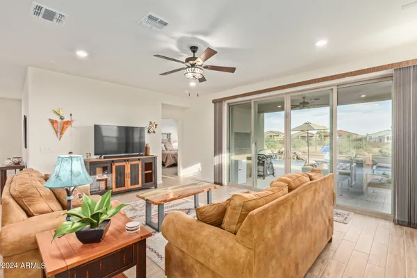 a living room with furniture a flat screen tv and a large window