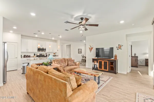 a living room with furniture appliances and kitchen view