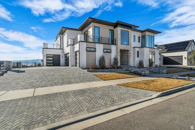 2152 South 30 West Orem, UT 84058 - Photo 2 of 56 Modern home with stone siding, stucco siding, decorative paver driveway, a balcony, and an attached garage