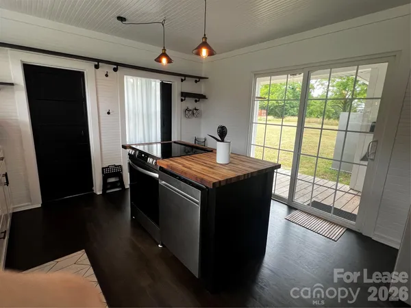 a view of hallway with window and wooden floor