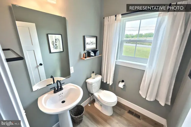 a bathroom with a sink a toilet and a mirror