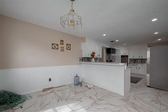 a view of kitchen with stainless steel appliances granite countertop cabinets and window