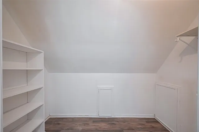 an empty room with wooden floor and window