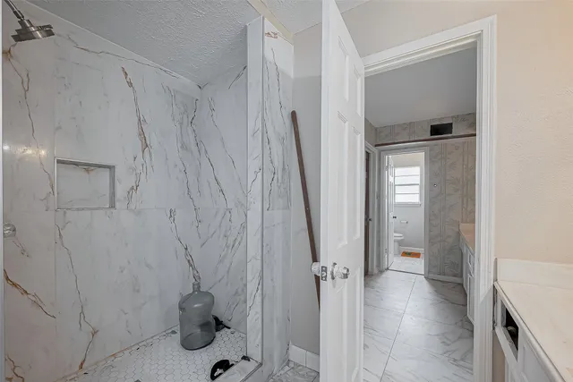 a bathroom with a sink a toilet and shower