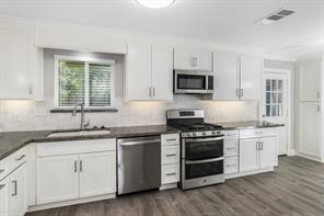 1539 Maux Drive Houston, TX 77043 - Photo 11 of 20 a kitchen with granite countertop white cabinets and stainless steel appliances
