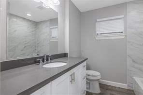 1539 Maux Drive Houston, TX 77043 - Photo 19 of 20 a bathroom with a granite countertop sink toilet and a mirror