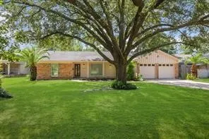 a front view of a house with a garden and trees