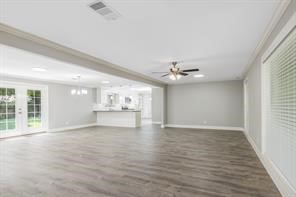 1539 Maux Drive Houston, TX 77043 - Photo 3 of 20 an empty room with wooden floor chandelier fan and windows