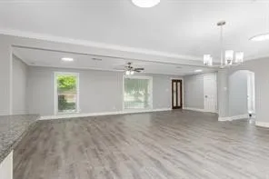 a view of an empty room with window and wooden floor
